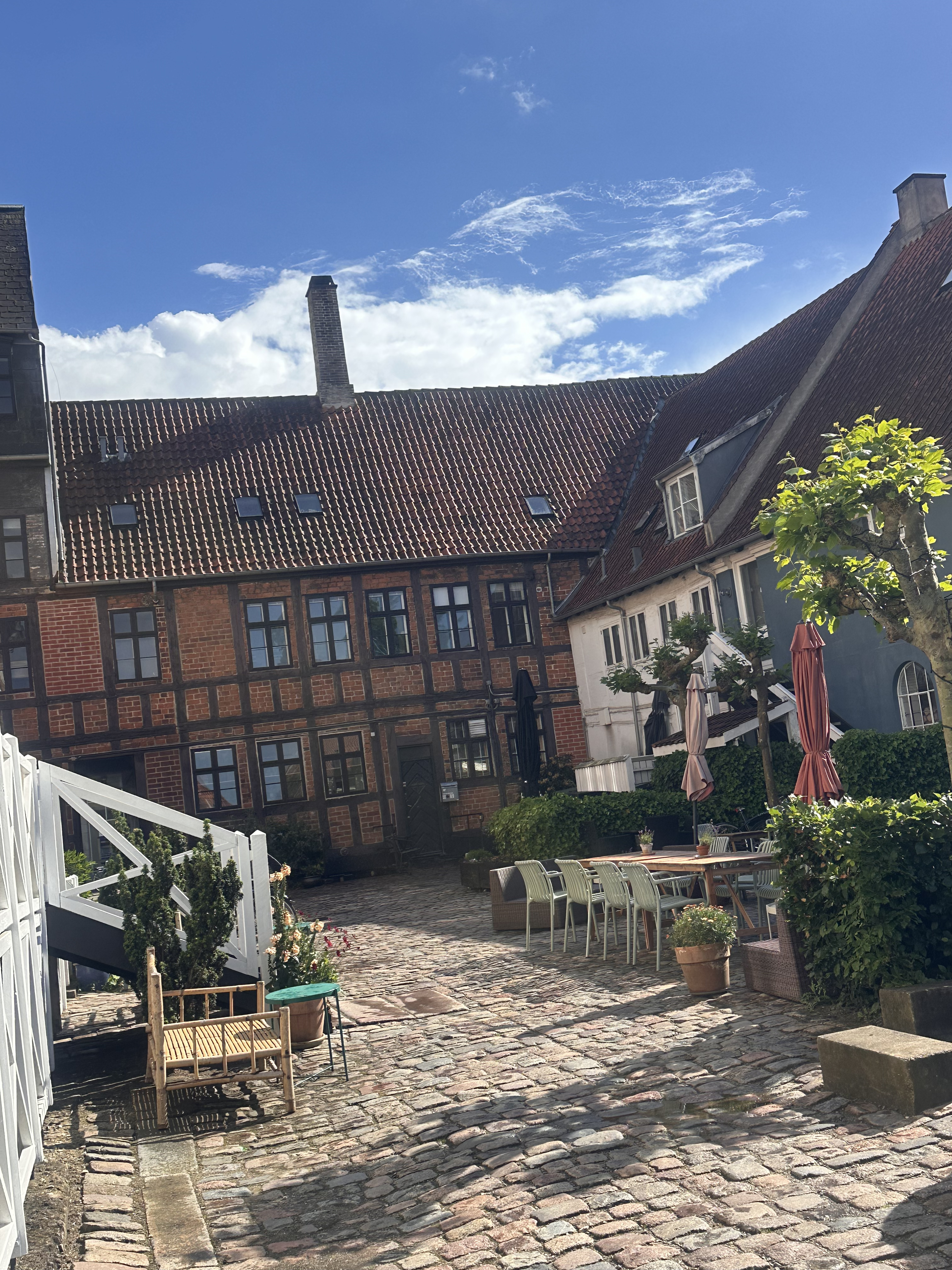 Brostensbelagt gårdhave med bindingsværkshuse i Roskilde